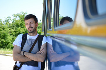 Young man leaning on a bus