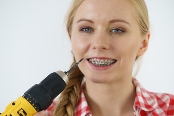 Wall Mural - Woman with braces using drill on her teeth