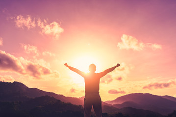 Copy space of man raise hand up on top of mountain and sunset sky abstract background.