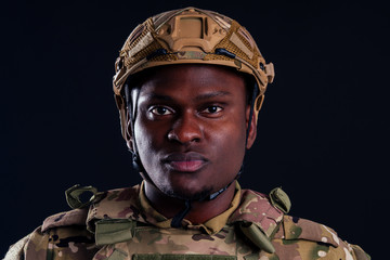 military army african male warrior camouflage suit sorrow sadness wrapped in an American flag black background studio ,lying violence news criminal media