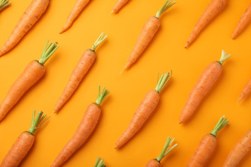 Flat lay composition with fresh carrots on color background