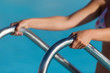 © pavel1964 - A woman hand holding a handrail in swimming pool