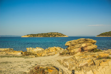 Wall Mural - Greece beach waterfront scenic landscape on Mediterranean island shoreline with view on sea and horizon line, beautiful summer vacation destination 