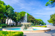 Quattro cavalli Four horses fountain with turquoise water in Parco Federico Fellini park with green trees in touristic city centre Rimini with blue sky background, Emilia-Romagna, Italy