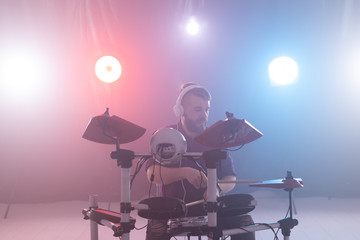 People, music and hobby concept - a man with headphones playing drums