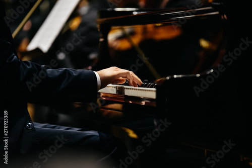 Fotografía Pianist playing a piece on a grand piano at a concert, seen from the side