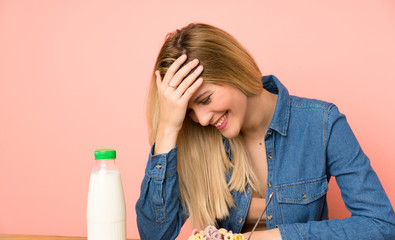 Wall Mural - Young blonde woman with bowl of cereals laughing