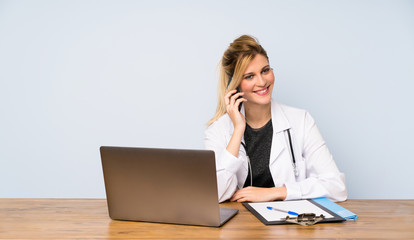 Wall Mural - Blonde doctor woman keeping a conversation with the mobile phone