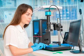 Canvas Print - Woman worker in control of Resin LCD / DLP / SLA 3D Printer in technology lab