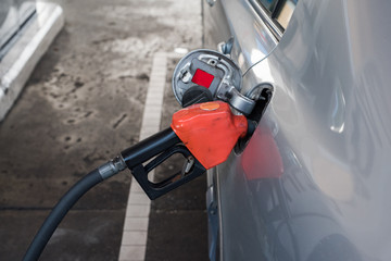 Pumping gasoline fuel in car at gas station