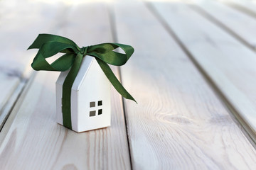 White paper house layout wrapped in green ribbon with bow. small gift great holiday