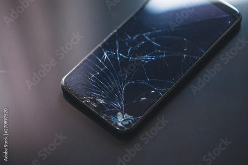 Cuadros en Lienzo Smartphone with broken touchscreen on black desktop