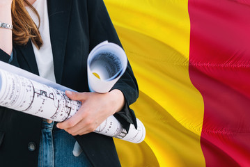 Chadian Architect woman holding blueprint against Chad waving flag background. Construction and architecture concept.