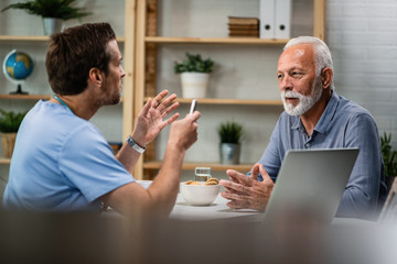 Wall Mural - Senior man talking with a doctor during medical appointment.