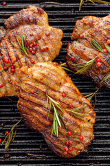 Wall Mural - Grilled pork steaks, pork neck with the addition of herbs and spices on the grill plate, top view, Grilled meat, bbq, barbecue