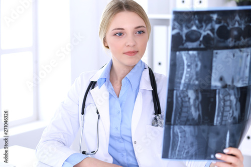 Cuadros en Lienzo Doctor woman examining x-ray picture near window in hospital