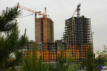 two tower cranes build skyscrapers