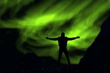 Green Northern Lights And Successful Human Silhouettes In The Sky