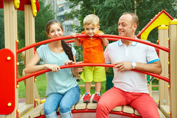 child with parents at playground. Mom, dad and son. playing family