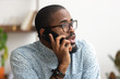 Close up african-american employee talking phone at workplace in office