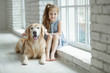 © nuzza11 - A child with an animal. Little girl with a dog at home.