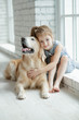 © nuzza11 - A child with an animal. Little girl with a dog at home.