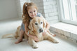 © nuzza11 - A child with an animal. Little girl with a dog at home.