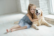 © nuzza11 - A child with an animal. Little girl with a dog at home.