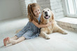 © nuzza11 - A child with an animal. Little girl with a dog at home.