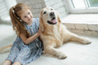 © nuzza11 - A child with an animal. Little girl with a dog at home.