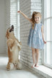 © nuzza11 - A child with an animal. Little girl with a dog at home.