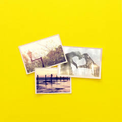 Wall Mural - top view of photos album over yellow wooden background. top view flat lay