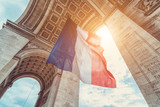 Fototapeta Londyn - french flag at arc de triomphe during bastille day