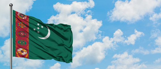 Turkmenistan flag waving in the wind against white cloudy blue sky. Diplomacy concept, international relations.