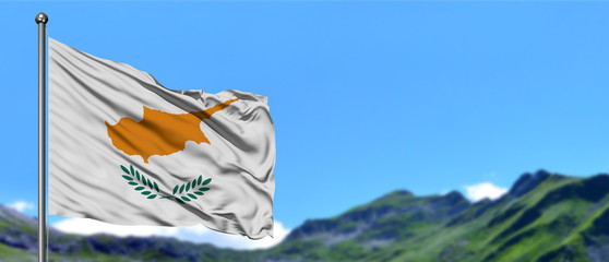 Cyprus flag waving in the blue sky with green fields at mountain peak background. Nature theme.