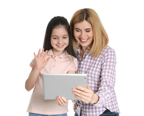 Wall Mural - Mother and her daughter using video chat on tablet against white background