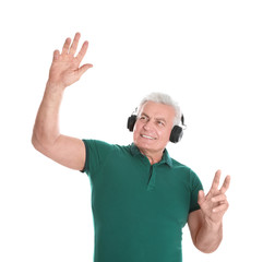 Wall Mural - Mature man enjoying music in headphones on white background