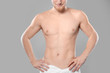 © New Africa - Young man with slim body in towel on grey background, closeup