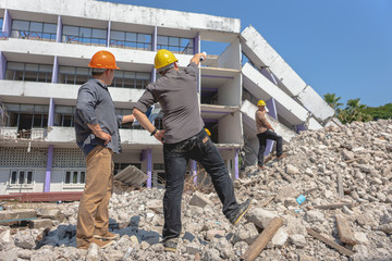 Engineer team and worker checking blueprint for emolition construction plan and inspect at the site.