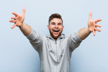 Young handsome fitness man feels confident giving a hug to the camera.