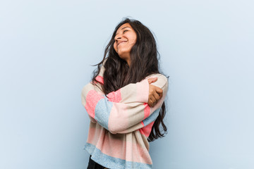 Wall Mural - Young fashion indian woman hugs himself, smiling carefree and happy.