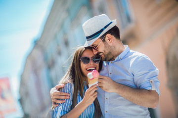 Wall Mural - Happy couple having date and eating ice cream after shopping