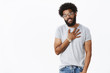 © Cookie Studio - Thanks mate I appreciate effort. Portrait of thankful cool and stylish african american guy holding palm on heart and smiling grateful giving thanks friends for help over gray background