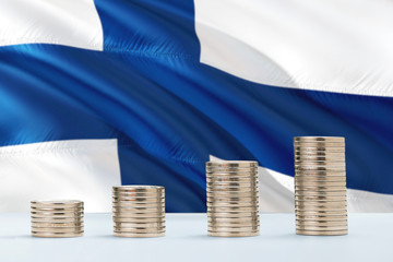 Finland flag waving in the background with rows of coins for finance and business concept. Saving money.