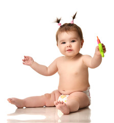 Wall Mural - Infant child baby girl toddler sitting in diaper happy smiling laughing playing with plastic toy ice cream isolated