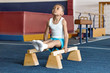 © Anatoliy Karlyuk - Picture of adorable dark skinned little gymnast competing on parallel bars. Hardworking talented African child exercising at gym, doing acrobatic moves, demonstrating strength, agility and flexibility