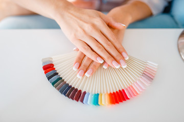 Female hands and colorful nail varnish palette