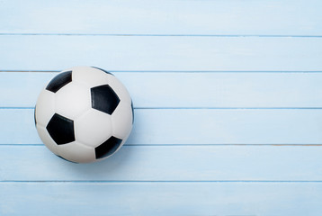 Wall Mural - Soccer ball or football on blue wooden floor