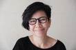 Portrait of happy and healthy natural looking middle aged Asian woman wearing glasses and smiling at camera, women's day, stop Asian hate concept 