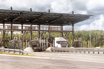 toll plaza on highway road with car traffic travel through pay point front closeup street view of money fee collection booth on expressway and vehicles modern urban transportation concept